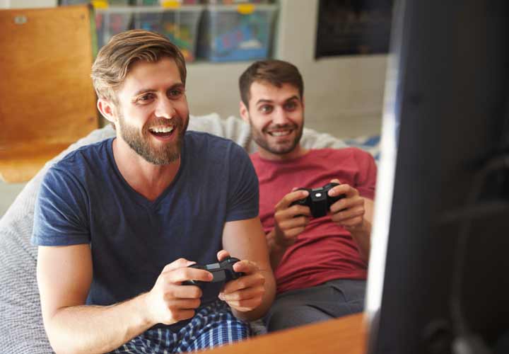 Two-Male-Friends-In-Pajamas-Playing-Video-Game-Together.jpg