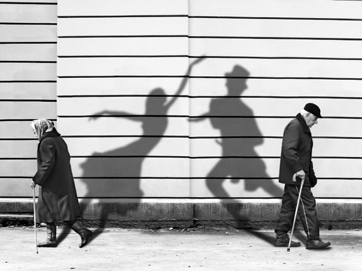 older-man-and-woman-walking-projecting-shadows.jpg