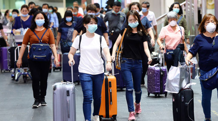 تعداد زیادی مسافر که ماسک زده‌اند - مسافری با چمدان - پیشگیری از کرونا در سفر