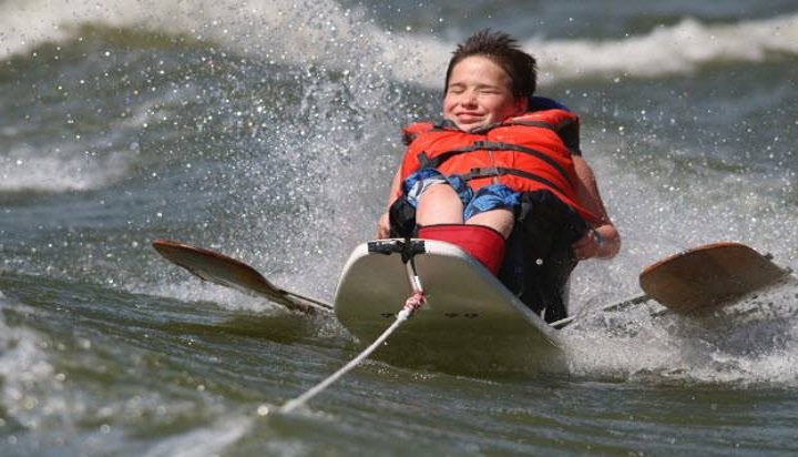 پسری درحال موج سواری با تخته باله دار