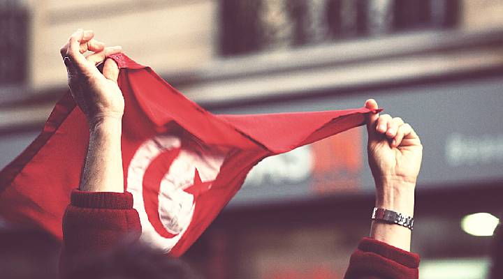 پرچم تونس در دست یک انقلابی
