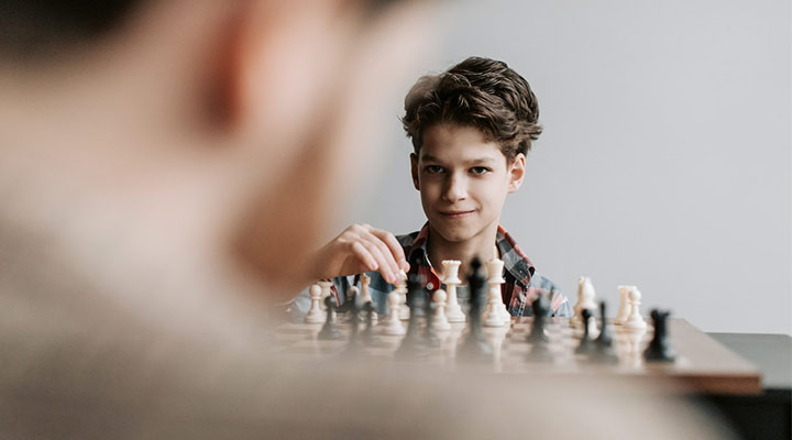 پسری در حال بازی شطرنج، بازی‌ای که با تعامل هوش سیال و هوش متبلور پیش می‌رود