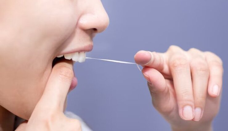 زنی در حال استفاده از نخ دندان