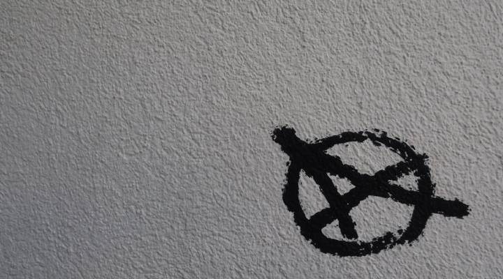 تصویری از نماد مشهور آنارشیسم روی دیواری سیمانی